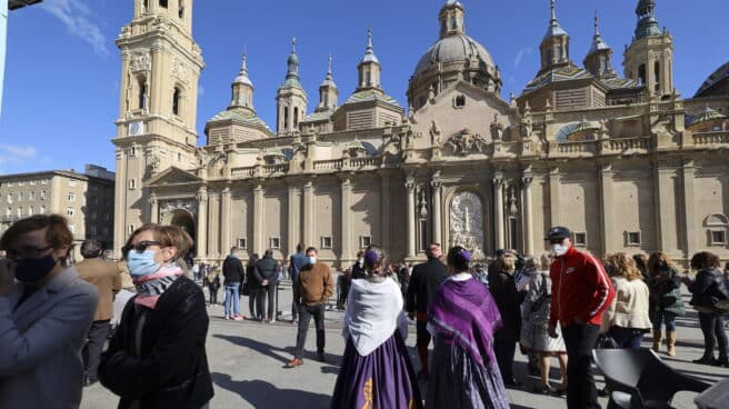 Varias personas vestidas de maños se concentran en las inmediaciones de la Basílica del Pilar