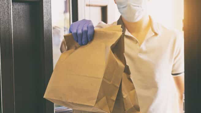food-delivery-man-wearing-gloves-and-face-mask-while-giving-the-order