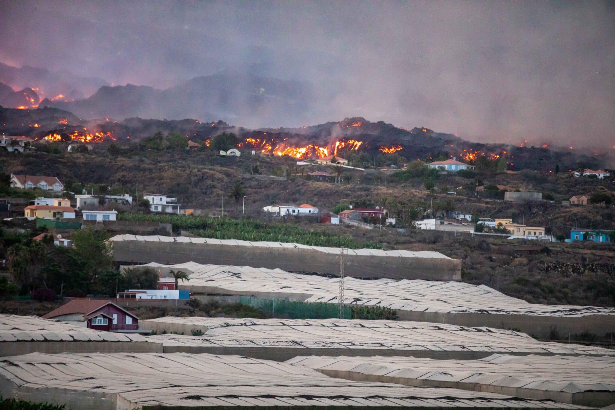 Vistas del volcán Cumbre Vieja expulsando lava y piroclasto, tomadas desde la montaña de La Lagunas donde hay invernaderos de plátanos, a 28 de septiembre en Las Manchas, La Palma, Santa Cruz de Tenerife, Canarias (España).