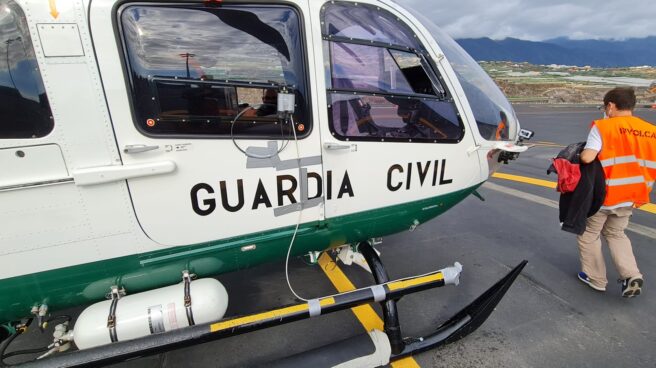 Un técnico de Involcan se sube a un helicóptero de la Guardia Civil.