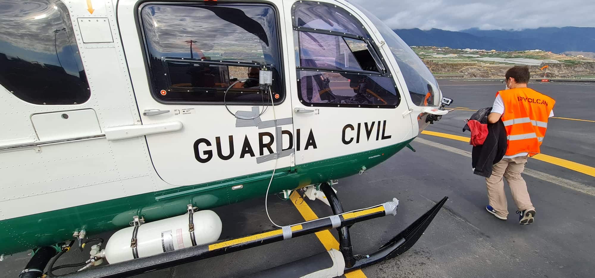 Un técnico de Involcan se sube a un helicóptero de la Guardia Civil.