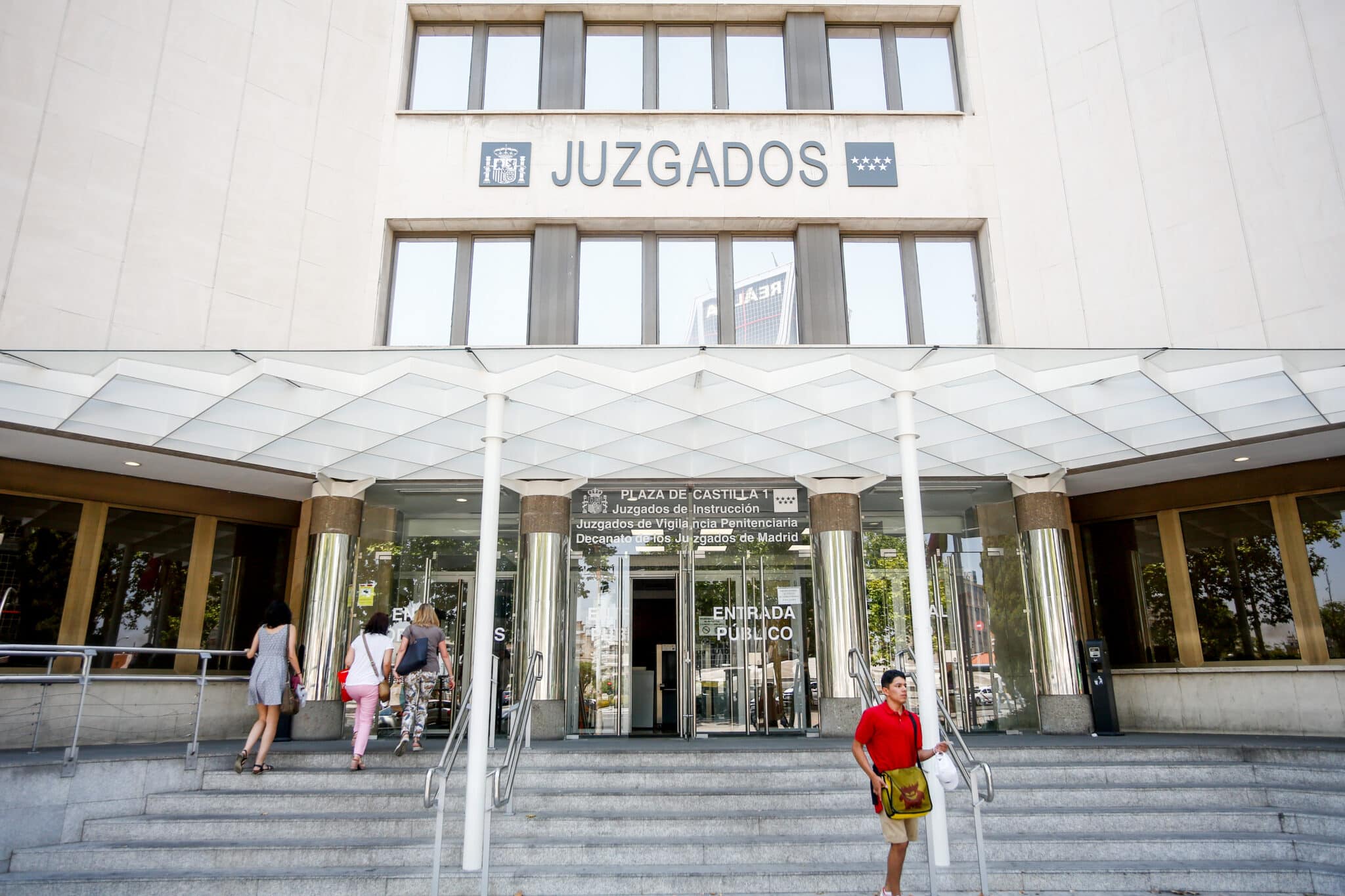 Personas entran por la puerta de los Juzgados de Instrucción ubicados en la Plaza de Castilla de Madrid.