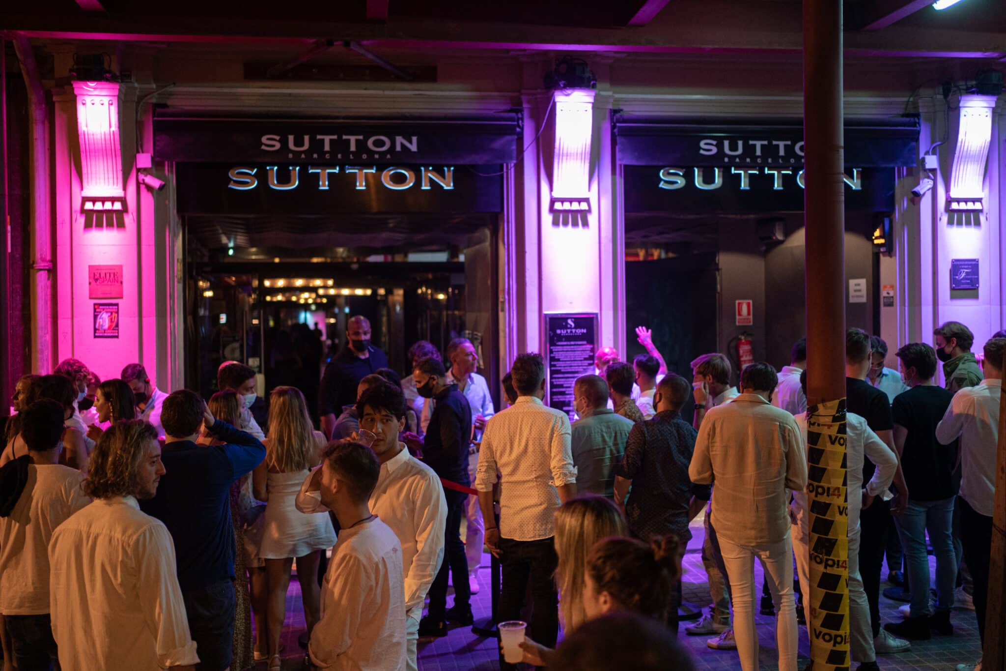 Jóvenes esperan en la puerta de la discoteca Sutton en Barcelona