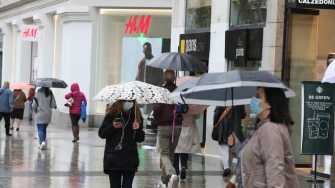 Transeúntes caminan por el centro de la capital protegiéndose de la lluvia con paraguas