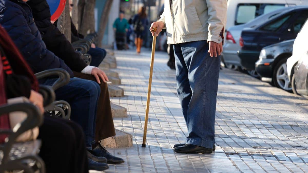 Imagen de personas mayores sentadas en un banco en la calle sin mostrar el rostro