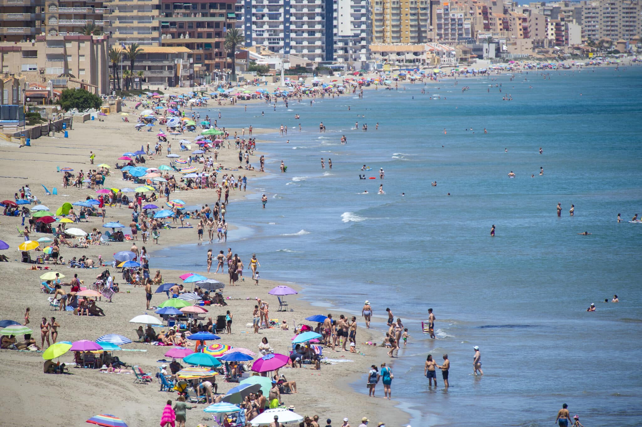 Varias personas se bañan en la Playa Galúa, en la Manga del Mar Menor.