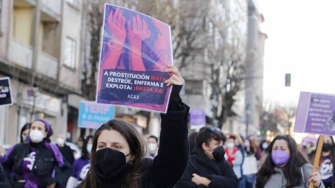 Desarticulan una banda que prostituía a mujeres en chalets de lujo en Vigo Una mujer sostiene una pancarta donde se lee "La prostitución mata, destruye, enferma y explota: ¡Basta ya!", durante una manifestación feminista convocada por Galegas8M en Vigo