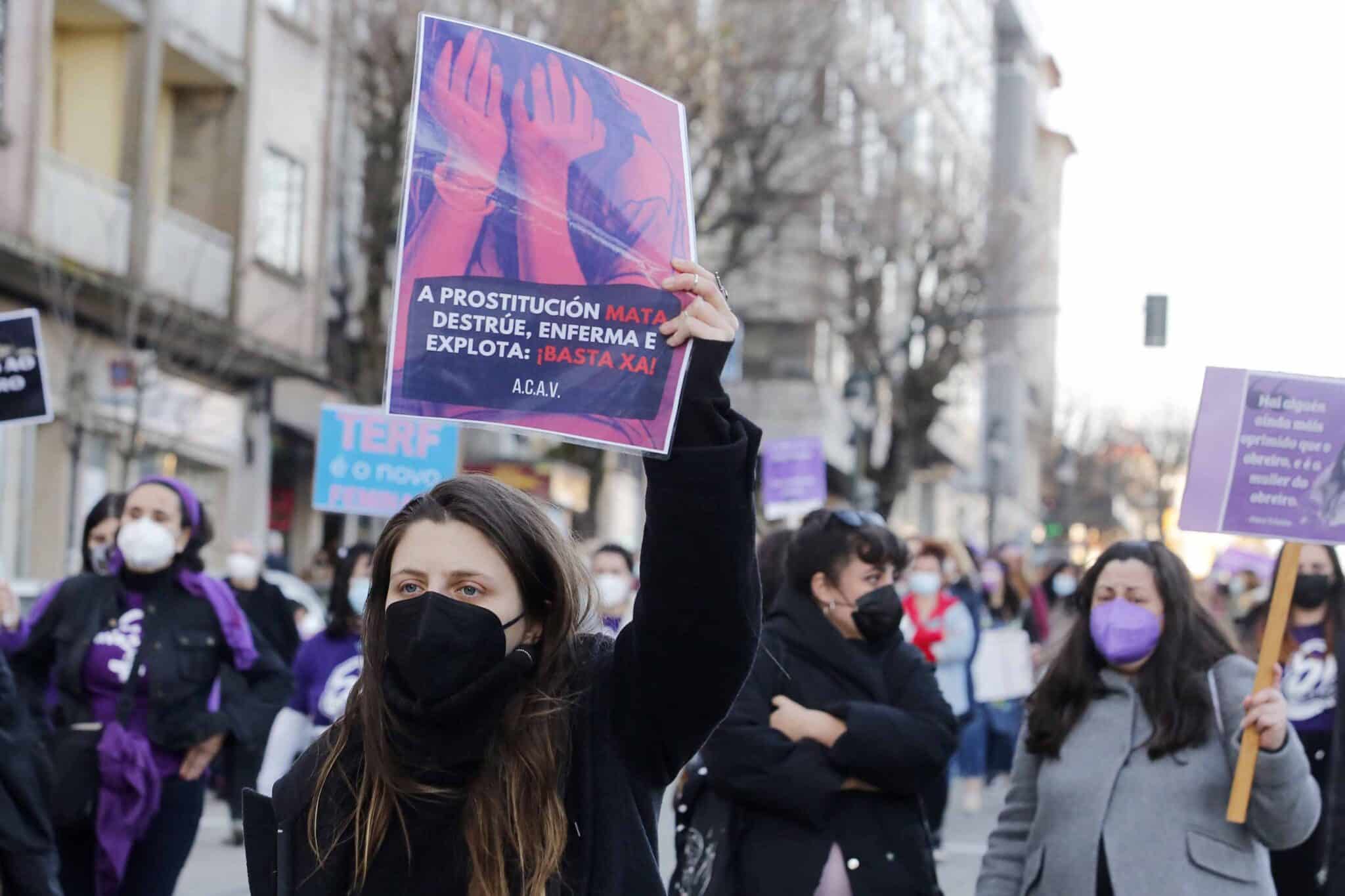 Una mujer sostiene una pancarta donde se lee "La prostitución mata, destruye, enferma y explota: ¡Basta ya!", durante una manifestación feminista convocada por Galegas8M en Vigo