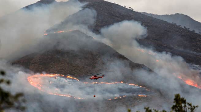 Controlado el incendio forestal en Sierra Bermeja (Málaga) Helicóptero contra incendio intentando apagar el fuego de la Sierra Bermeja, visto desde el cerro de la Silla de los Huesos
