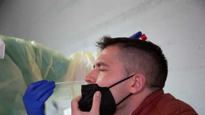 Una sanitaria realiza un test de antígenos o una PCR a un hombre, en un dispositivo de cribado masivo instalado en el Hospital Perpetuo Socorro, en Badajoz