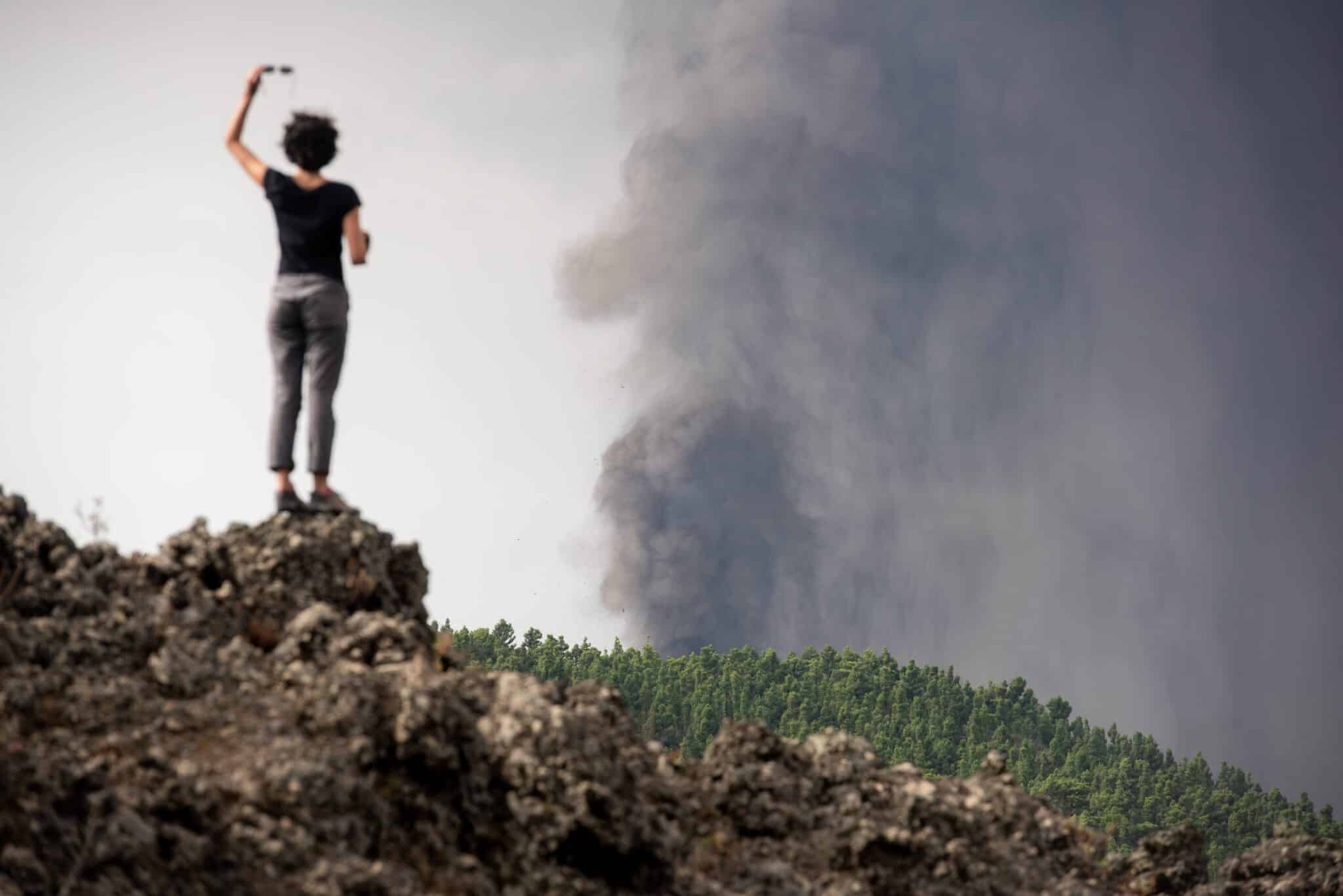 Una mujer fotografía el volcán con el móvil