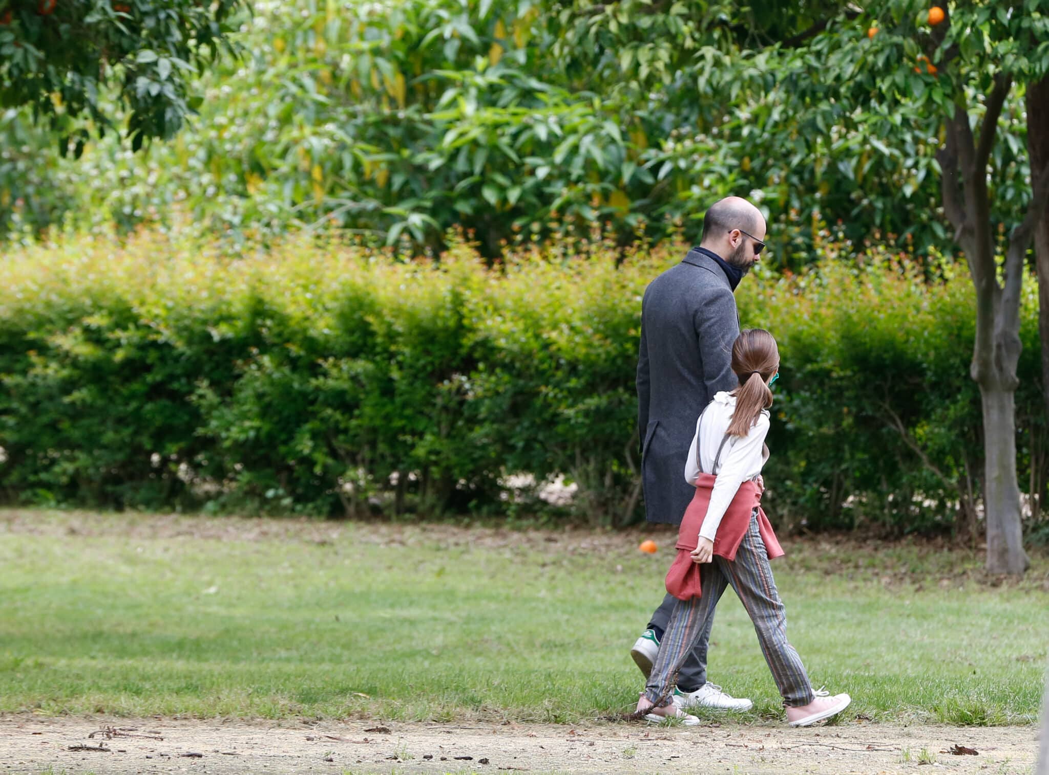 Un padre con su hija paseando por el Parque de Maria Luisa