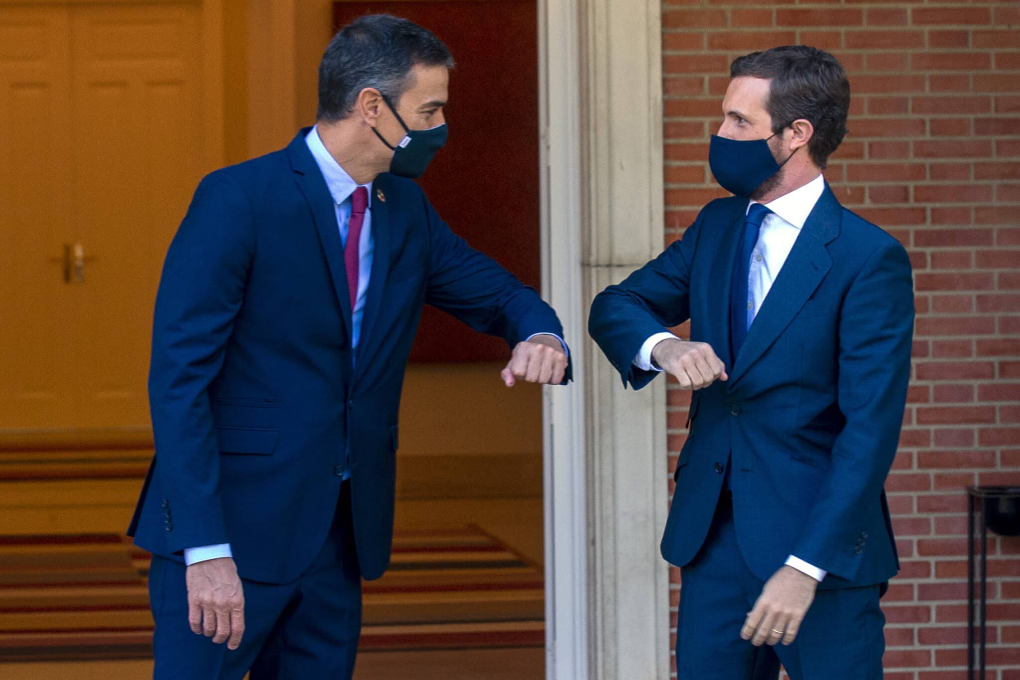 El presidente del Gobierno, Pedro Sánchez y el presidente del PP, Pablo Casado, se saludan con el codo en el Palacio de Moncloa