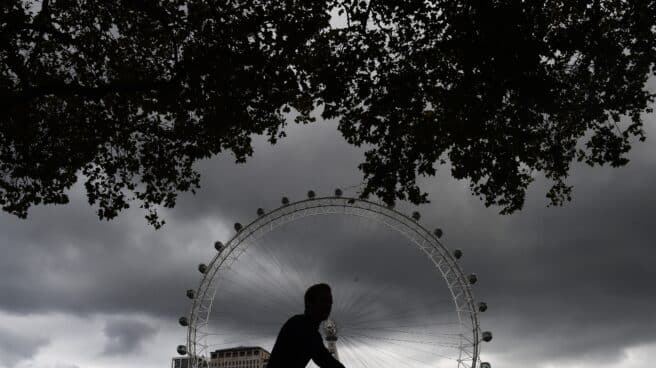 reino-unido-pandemia-covid Un hombre en bicicleta pasa al lado de la noria de Londres.