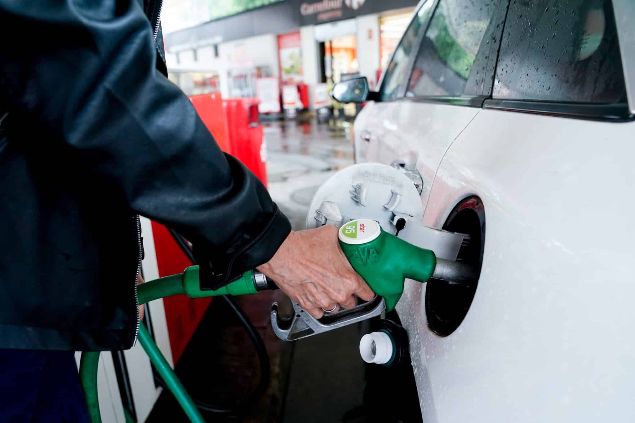 Mujer pone gasolina en un vehículo blanco de una gasolinera en Madrid