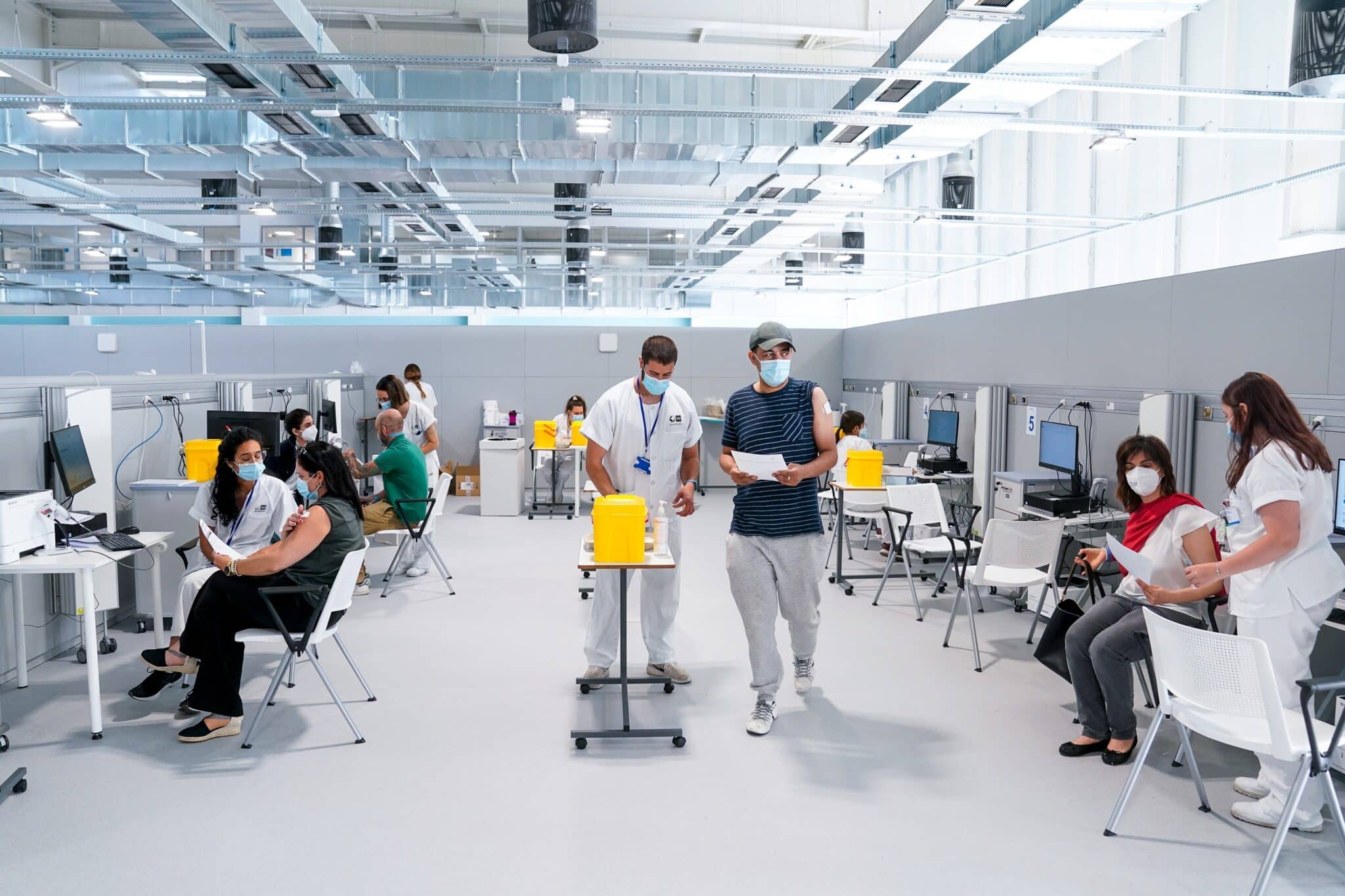 Enfermeros y pacientes en las instalaciones del Hospital público de emergencias Enfermera Isabel Zendal, a 28 de junio de 2021, en Madrid, (España). A partir de hoy este hospital va a comenzar a vacunar contra el Covid-19, 24 horas al día, a través del sistema de autocitación. En el recinto se pondrán en torno a 150.000 vacunas a la semana de manera ininterrumpida.