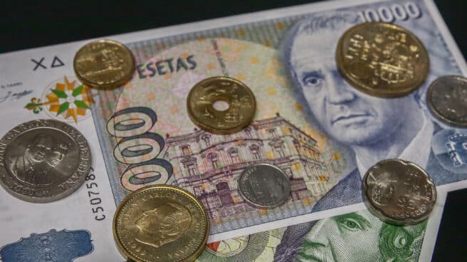 30 de junio, fecha límite para cambiar pesetas Varias monedas encima de dos billetes de las antiguas pesetas.