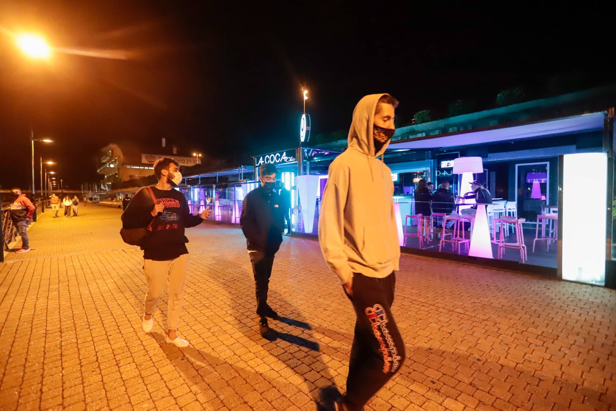 Jóvenes pasean por una zona de locales de ocio nocturno