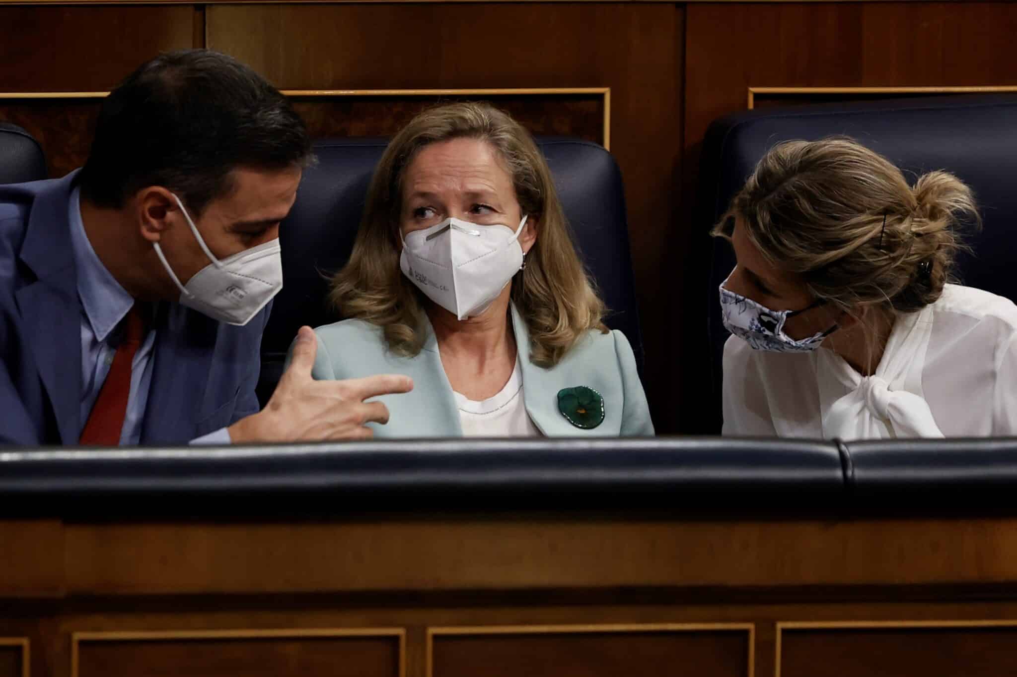 La ministra de Trabajo, Yolanda Díaz (d), conversa con el presidente del Gobierno, Pedro Sánchez, y con la vicepresidenta primera Nadia Calviño.