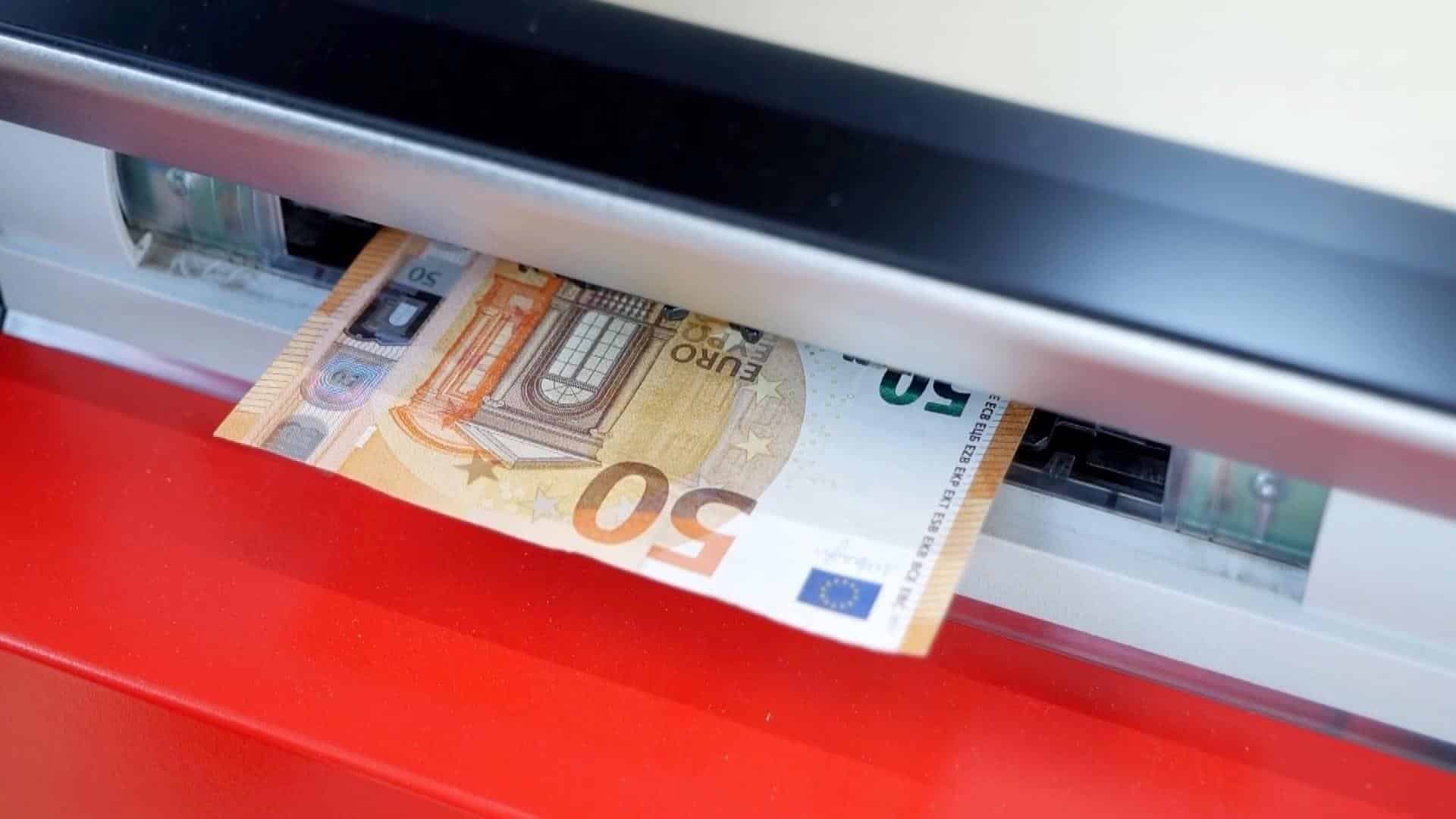 Un billete de cincuenta euros sale de un cajero.