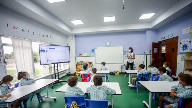 Varios niños escuchan las explicaciones de su profesora en una clase del colegio Virgen de Europa durante el primer día de clase del curso 2021-22, a 6 de septiembre de 2021, en Boadilla del Monte, Madrid (España). El tercer curso escolar en un contexto de pandemia arranca esta semana en toda España, con el 39,4% de los jóvenes mayores de 12 años vacunados con pauta completa contra la COVID y prácticamente el 100% de los profesores, así como las mismas medidas sanitarias para evitar contagios del curso anterior.