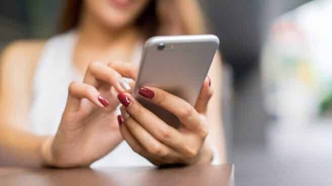 Una joven utiliza un teléfono móvil. Una joven utiliza un teléfono móvil.