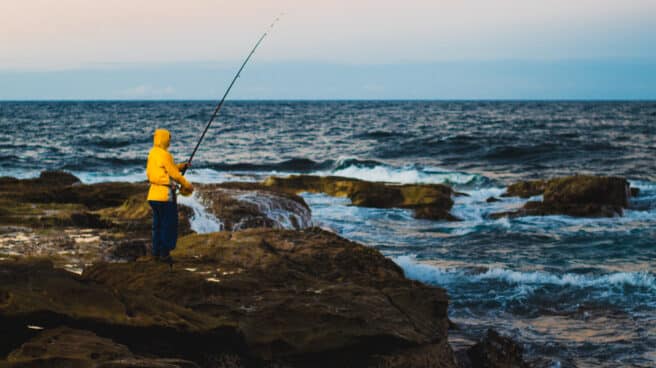 Pescador en una zona rocosa junto al mar