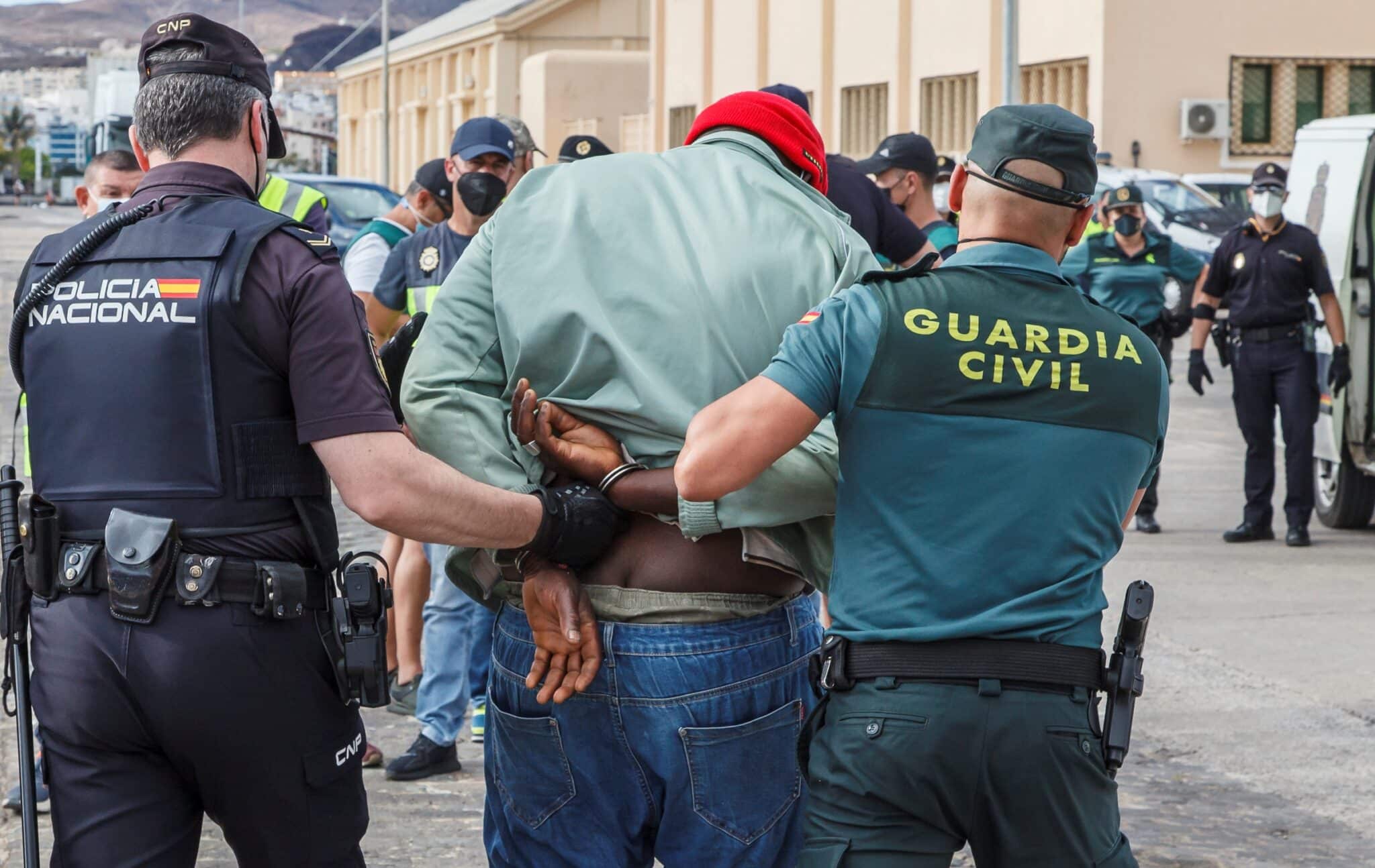 Un policía y un guardia civil conducen detenido a un hombre en una operación antidroga.