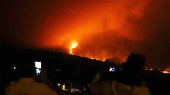 Varias personas observan el avance de la lava desde el mirador de Tajuya.