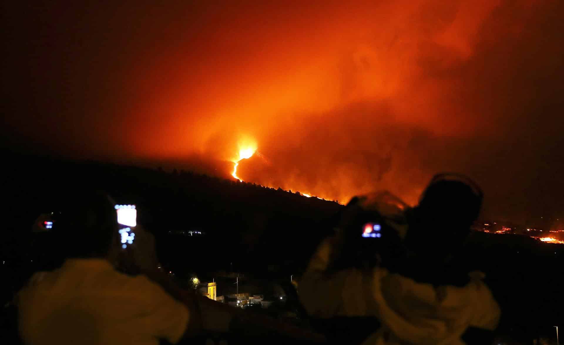 Varias personas observan el avance de la lava desde el mirador de Tajuya.