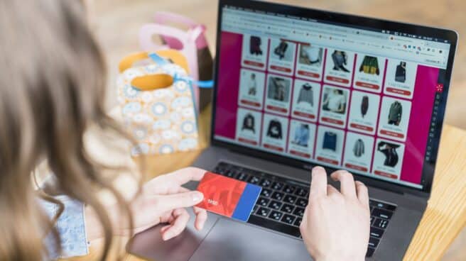 woman-holding-credit-card-in-front-of-laptop-with-shopping-website