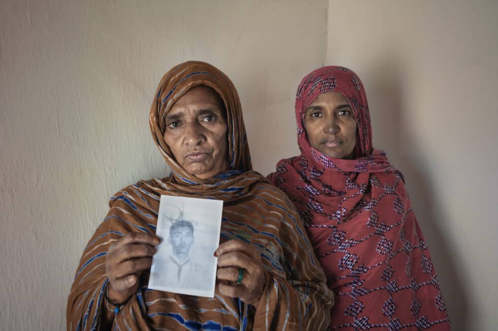 Dos mujeres muestran el retrato de un familiar desaparecido. Unos 400 saharauis han desaparecido desde principios de los años setenta en el marco del conflicto armado y la represión política de Marruecos contra la población civil de las zonas ocupadas. Durante décadas no hubo ningún tipo de información sobre el paradero de los desaparecidos. El gobierno marroquí reconoció en 1999 que 43 desaparecidos saharauis habían muerto durante la detención. En diciembre de 2010, el Consejo Consultivo de Derechos Humanos de Marruecos publicó en internet un informe con referencia a 207 casos de desaparecidos, dándoles por muertos “debido a las condiciones del encarcelamiento”, “en medio de sufrimientos” o en “enfrentamientos militares”. Según la Asociación de Familiares de Presos y Desaparecidos Saharauis (AFAPREDESA), las informaciones proporcionadas fueron limitadas, fragmentadas e imprecisas. Tampoco se informó sobre el destino final de los cuerpos de las víctimas. La desaparición forzada es un crimen de lesa humanidad y tiene carácter de delito permanente. Campamento saharaui de Auserd, octubre de 2016