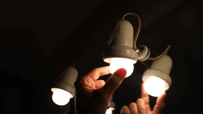 El precio de la luz vuelve a subir este lunes, hasta alcanzar los 167,67 euros/MWh Una persona cambia la bombilla de una lámpara