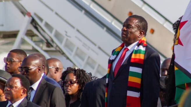 El presidente de Zimbabwe, Emmerson Mnangagwa (R), se encuentra durante la llegada del ataúd del ex presidente de Zimbabwe, Robert Mugabe