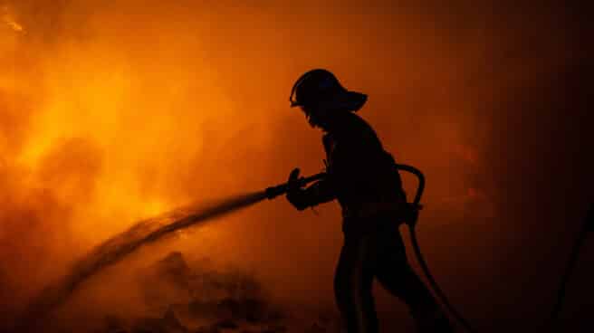 Un bombero trabaja para apagar los fuegos en Barcelona