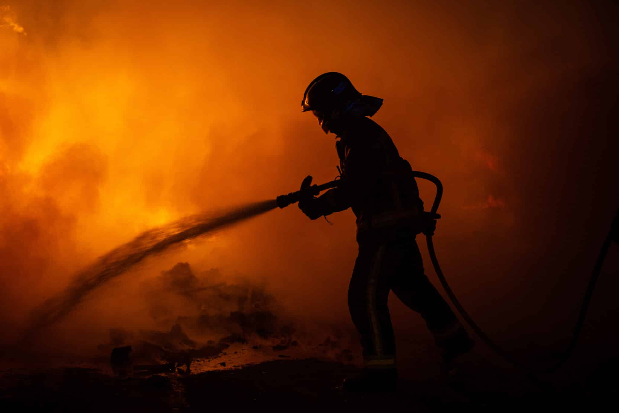 Un bombero trabaja para apagar los fuegos en Barcelona