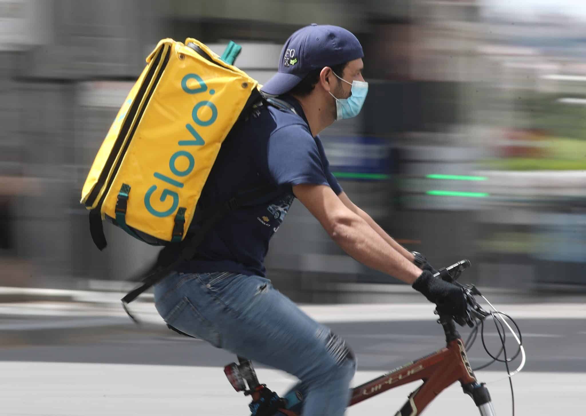 Un repartidor de Glovo monta una bicicleta.