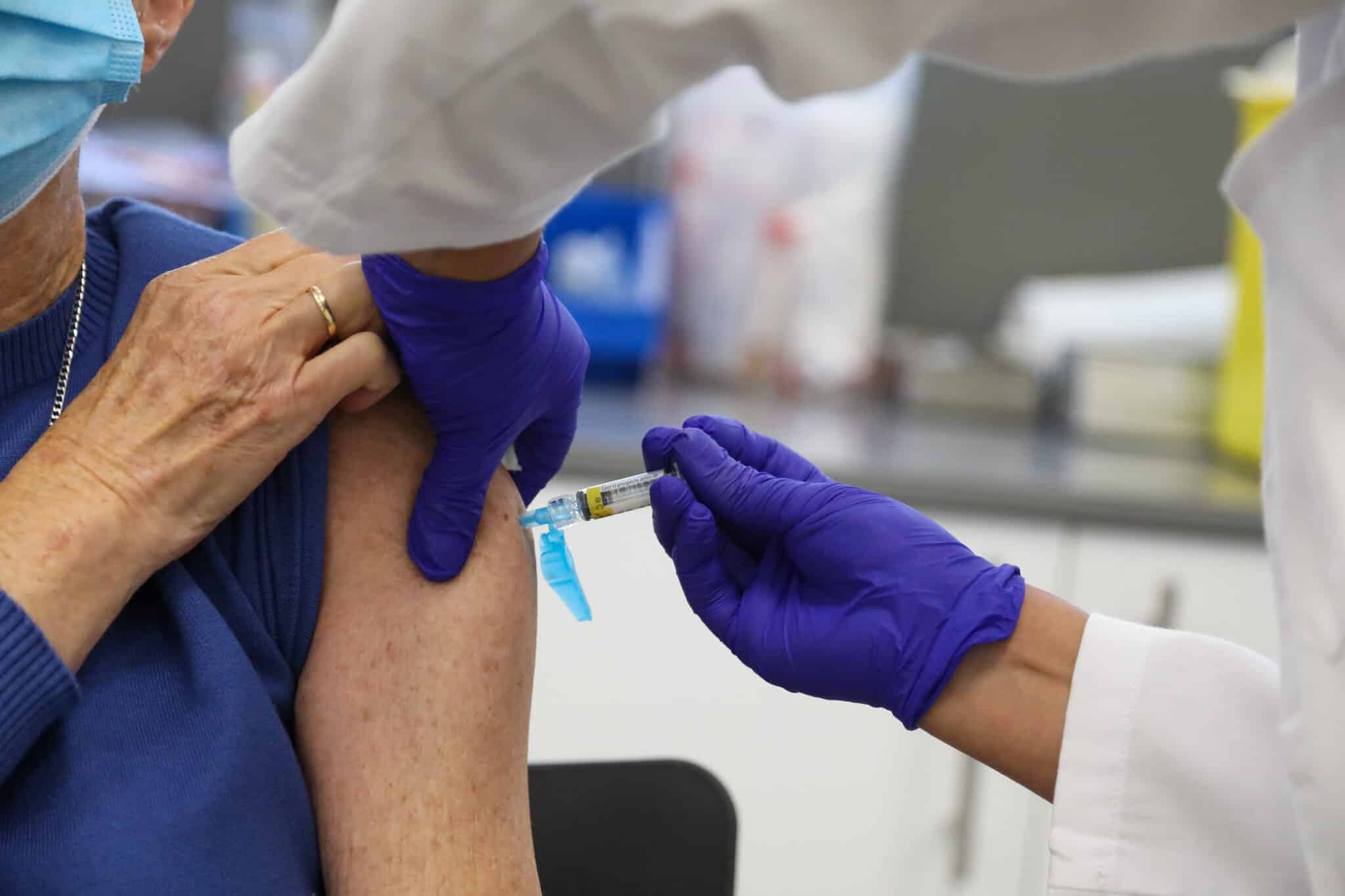 Una persona mayor se vacuna contra la gripe en el centro de Salud Baviera.