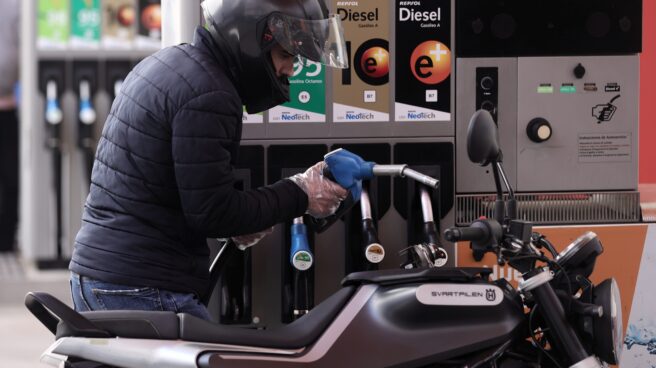 Un hombre inyecta carburante en una moto en Madrid