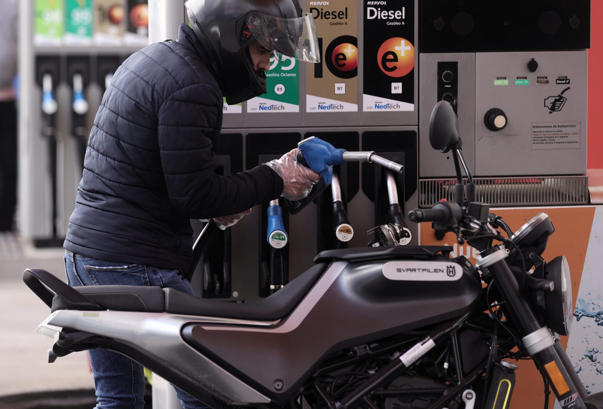 Un hombre inyecta carburante en una moto en Madrid
