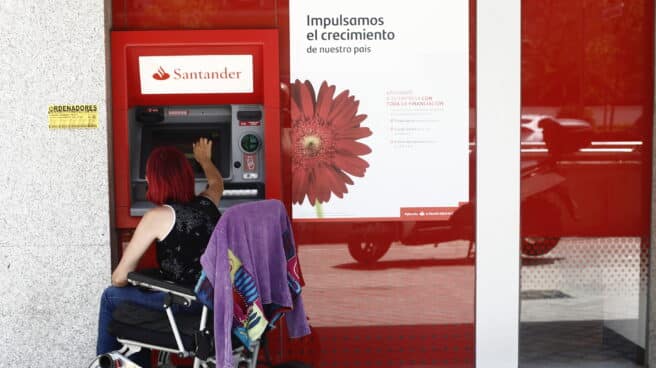 Imágenes de recurso de cajeros en Madrid Una mujer en silla de ruedas saca dinero en un cajero del Banco Santander en Madrid.