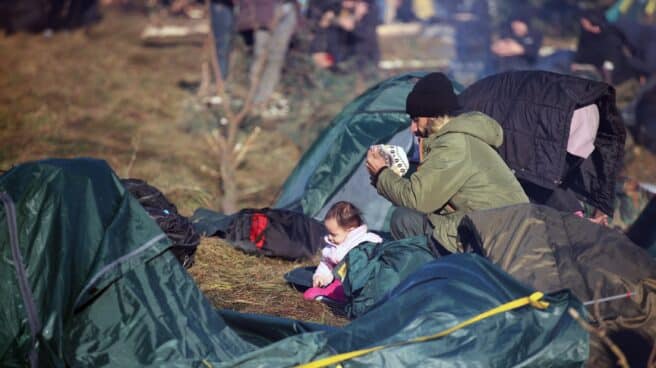 Un hombre y su bebé acampados en la frontera entre Bielorrusia y Polonia