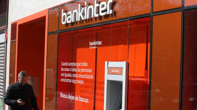 Un hombre pasa al lado de un cajero del banco Bankinter en una de sus oficinas