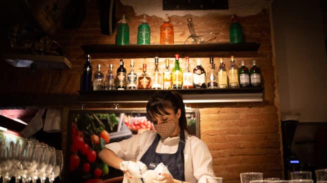 Cataluña abrirá al 100% sus equipamientos culturales, el deporte al aire libre y los bares y restaurantes a partir del viernes Una camarera seca unos vasos en el interior de un bar en una calle céntrica de Barcelona.