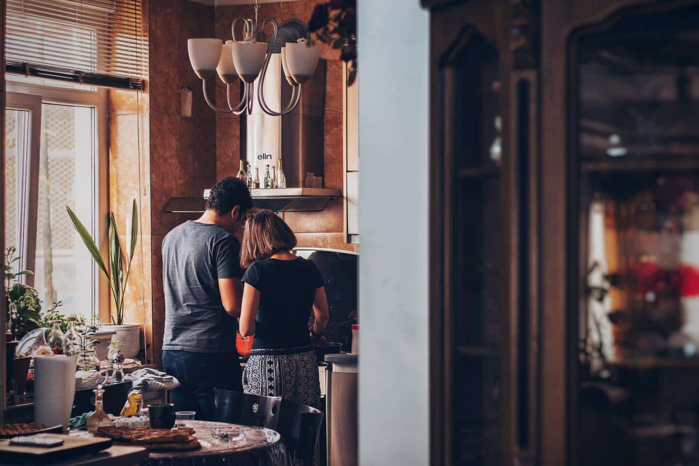 Dos personas cocinan juntos en un hogar.