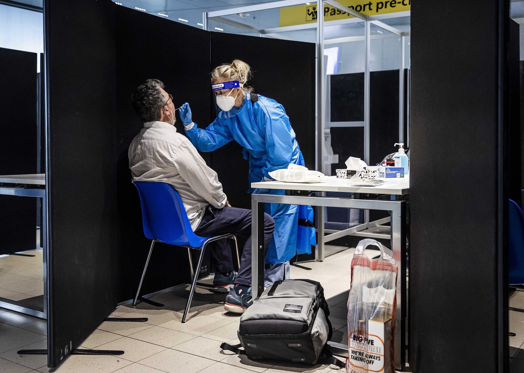 Una sanitaria realiza un test en el aeropuerto de Schipol, en Ámsterdam, a un pasajero procedente de Sudáfrica