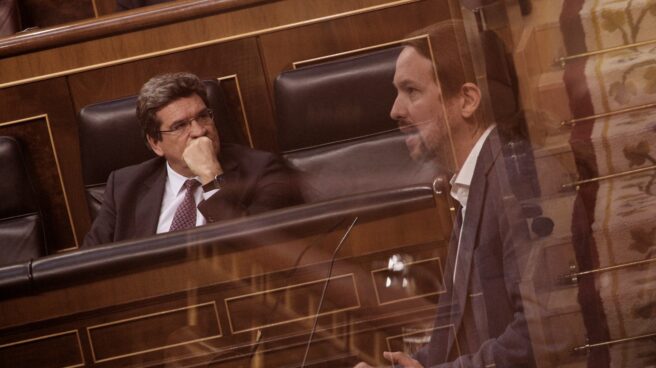José Luis Escrivá escucha a Pablo Iglesias durante un pleno en el Congreso, en el año 2020.