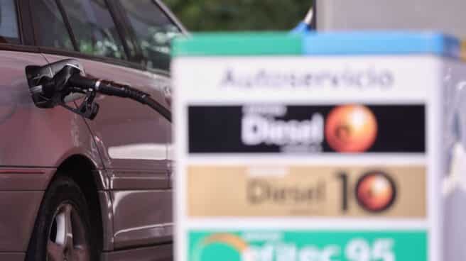 Un coche reposta en una gasolinera. Un coche reposta en una gasolinera.