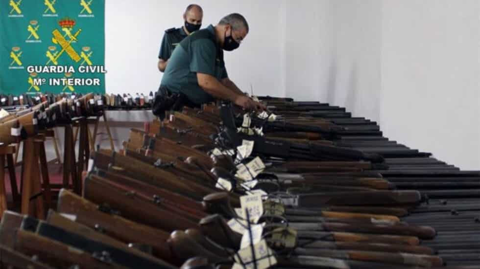 Agentes de la Guardia Civil, ante las armas expuestas en una de las subastas.