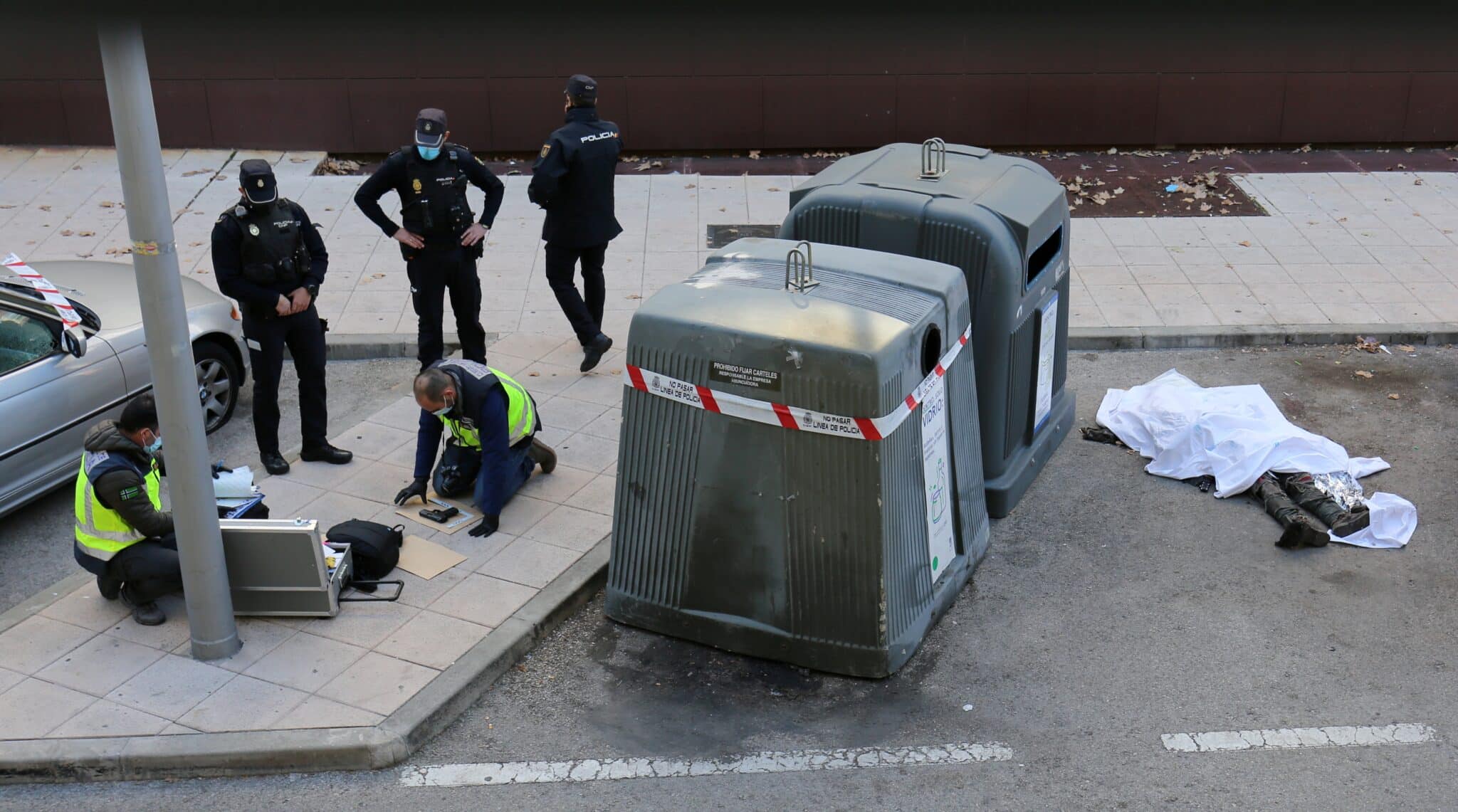 Varios policías nacionales, a pocos metros del cuerpo del hombre abatido en el distrito madrileño de Villaverde.